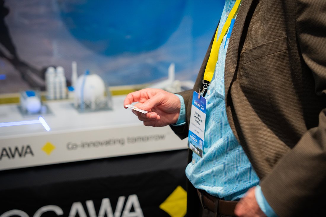 Delegate holding business card at american hydrogen forum